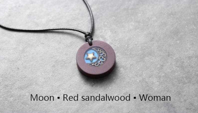 May include: A necklace with a dark red sandalwood pendant featuring a crescent moon and a gold star design.