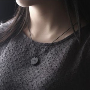 May include: A black necklace with a round pendant that says "Feng" on it.