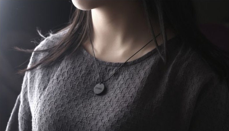 May include: A black necklace with a round pendant that says "Feng" on it.
