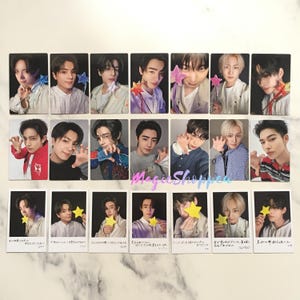 May include: A collection of twenty-one photo cards featuring young men. The cards are arranged in three rows, each card showing a different pose and expression. Some cards include star-shaped props, and some have Japanese text.