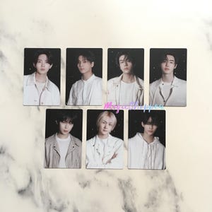 May include: Seven rectangular photo cards featuring portraits of young people in various white outfits against a dark background. The cards are arranged in two rows, with the subjects looking directly at the viewer.
