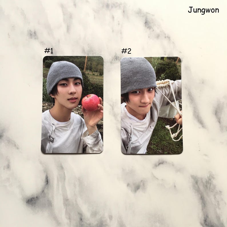 May include: Two photo cards featuring a person wearing a gray beanie and a white shirt. One card shows the person holding a red apple. The other card shows the person holding a rope. The name "Jungwon" is in the top right corner.