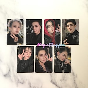 May include: Seven rectangular photo cards featuring portraits of young individuals with dark hair and varied styling, including one person in a red hooded jacket. Each card displays a person making a peace sign gesture. The text MagicShopper is visible.