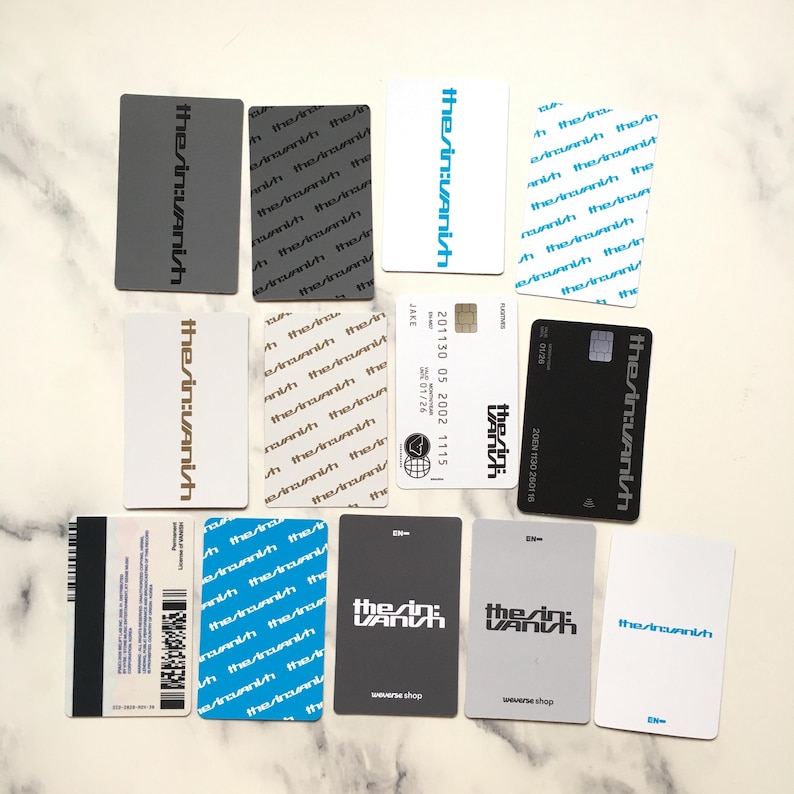 Op de afbeelding: Een verzameling rechthoekige kaarten met de tekst "the/in:Vanish" in verschillende kleuren en stijlen. Sommige kaarten hebben extra tekst en afbeeldingen, waaronder een creditcardontwerp en een streepjescode.