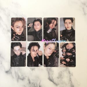 May include: Eight rectangular photo cards featuring images of people in black outfits. The cards have a glossy finish and are arranged in two rows of four. The people in the photos have various hairstyles and expressions.