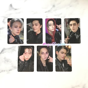 May include: Set of seven rectangular photo cards featuring portraits of young men. The cards have a black border and the subjects are wearing various outfits, including jackets and hoodies. Some cards show the subjects making heart gestures.