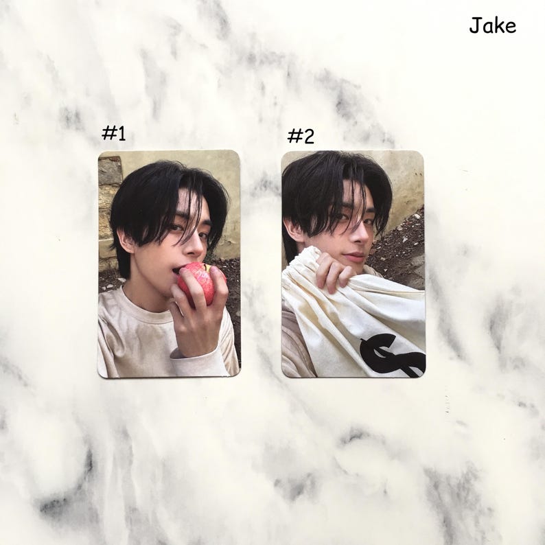 May include: Two rectangular cards featuring a person. Card #1 shows the person eating a red apple. Card #2 shows the person holding a white bag with a black graphic. The name "Jake" is written in the top right corner.