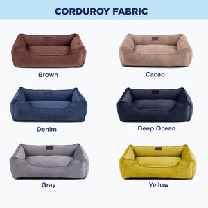 May include: Six dog beds in different colors, including brown, cacao, denim, deep ocean, gray, and yellow. The beds are made of corduroy fabric and have a rectangular shape with a raised edge.