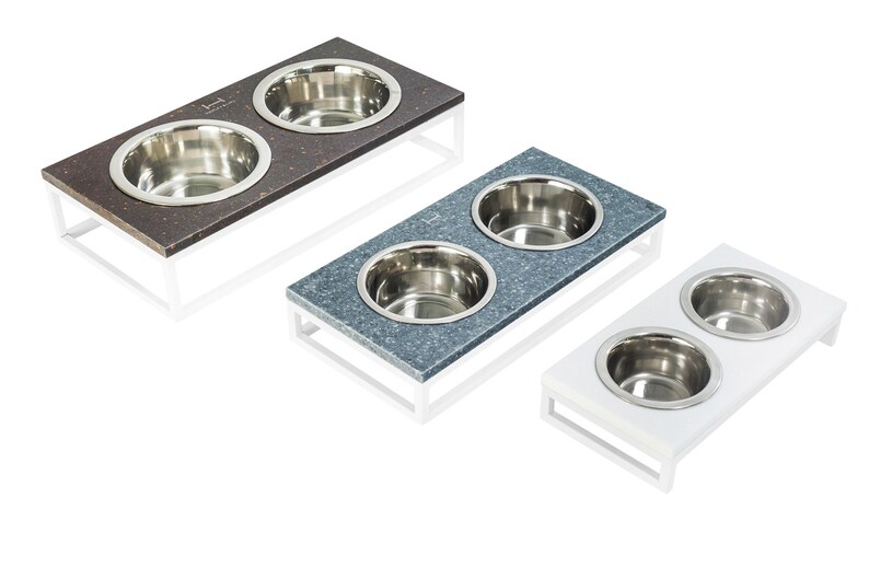 May include: Three elevated pet food and water bowls with stainless steel bowls. The bowls are on a white, gray, and brown platform with a white metal frame.