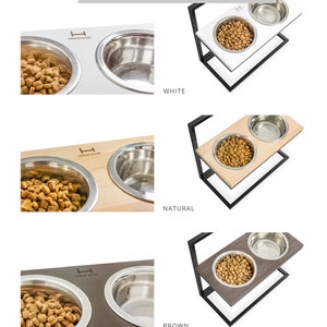 K&ouml;nnte beinhalten: Ein Satz mit zwei erh&ouml;hten Hunden&auml;pfen mit einem schwarzen Metallrahmen und einer Holzplatte. Die Holzplatte ist in drei Farben erh&auml;ltlich: Wei&szlig;, Natur und Braun. Die N&auml;pfe sind aus Edelstahl und haben den Text "Harley & Co" auf der Seite eingraviert.