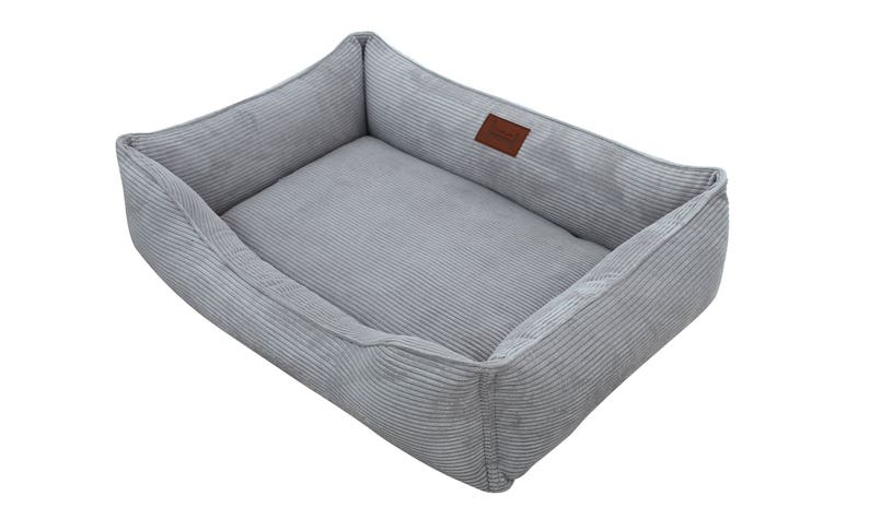 May include: A gray corduroy dog bed with a rectangular shape and a raised edge. The bed has a soft, plush lining and a brown leather label.