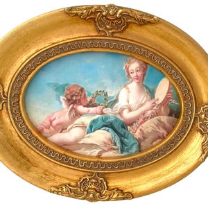 Puede incluir: Pintura ovalada en un marco dorado, que representa una escena clásica. Un querubín ofrece una corona a una mujer que sostiene un espejo. La obra presenta colores suaves y un marco ornamentado y detallado.
