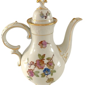 May include: Cream-colored porcelain teapot with a lid, handle, and spout. The teapot is decorated with colorful floral patterns in pink, blue, and orange, with gold trim accents. A classic piece for serving tea.
