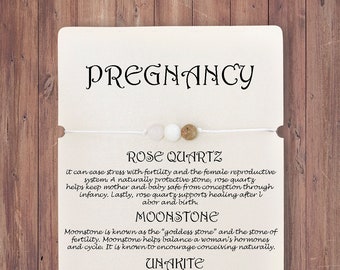 Könnte beinhalten: Eine weiße Karte mit dem Wort "PREGNANCY" in schwarzer Schrift. Die Karte zeigt ein Armband mit Rosenquarz-, Mondstein- und Unakit-Perlen. Text beschreibt die Eigenschaften der Steine.