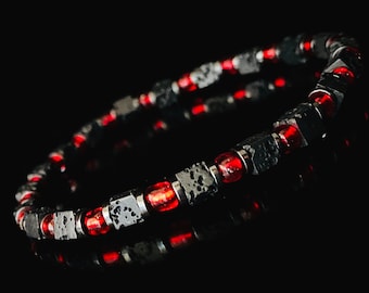 May include: A black and red beaded bracelet with lava rock and red glass beads.