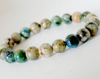 May include: A bracelet made of round, green, blue, and white gemstone beads.