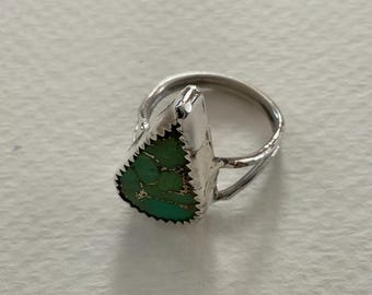 May include: A silver ring featuring a triangular, green, matrix-patterned stone set in a serrated bezel. The band is constructed from two thin, textured silver wires that meet at the base of the stone setting, creating an open, split-shank design.