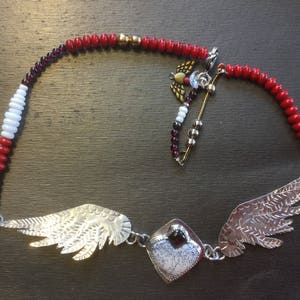 A Sterling Silver Winged Heart Shaped Merlinite and Garnet Pendant Necklace with Garnet, Brass, and Glass Beads