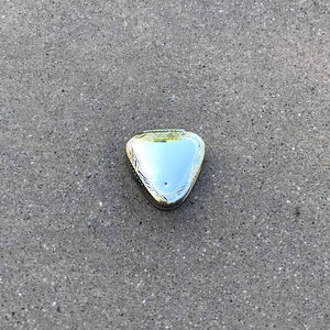 May include: A silver triangle-shaped trinket box with an ornate design.