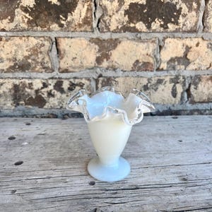 May include: A handmade wooden sign with the text "Welcome to our home" in a handwritten style. The sign is painted white with black lettering and a distressed finish, perfect for home decor.