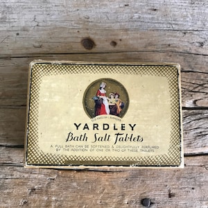 May include: A vintage box of Yardley Bath Salt Tablets in a gold and white design. The box features a picture of three women in period clothing and the text "Old English Lavender". The box also includes the text "Yardley Bath Salt Tablets" and "A full bath can be softened & delightfully perfumed by the addition of one or two of these tablets".