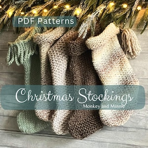 Op de afbeelding: Vier handgebreide kerstsokken in saliegroen, lichtbeige, donkerbruin en crème met bruine spikkels. De sokken hebben een ribbelsteek textuur en een kwastje aan de rechterkant. Tekst: PDF Patterns Christmas Stockings Monkey and Minnie.