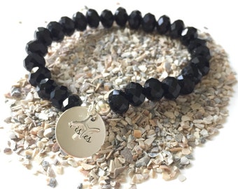 Black Roundel Swarovski beaded bracelet with a Sterling Silver zodiac charm, finished with Sterling Silver beads.