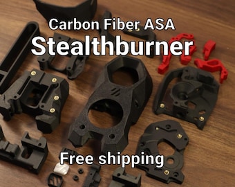 Puede incluir: Un conjunto de piezas impresas en 3D Carbon Fiber ASA Stealthburner en negro y rojo, con varios componentes geométricos con inserciones de latón integradas, junto con el texto Carbon Fiber ASA Stealthburner.