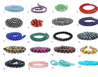 May include: Assortment of 20 strands of round gemstone beads. The beads are in various colors, including blue, green, red, black, brown, purple, and pink. Each strand is labeled with a number from 1 to 20.