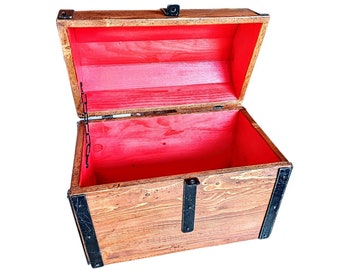 May include: An open wooden treasure chest with a red felt lining. The chest has black metal hinges and clasps.
