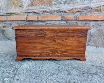 May include: A wooden storage box with a natural wood finish. The box has a hinged lid and a simple design.