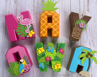 May include: A set of six three-dimensional paper letters spelling MAY NOW, decorated with tropical motifs including a pink flamingo, a pineapple, a tiki mask, a parrot, hibiscus flowers, palm leaves, and a palm tree. Sweet Buttercup Designs.