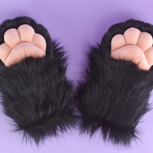 May include: A pair of black furry paw hand warmers with pink paw pads.