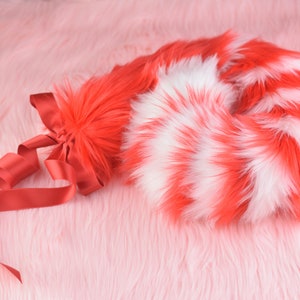 May include: A red and white striped fluffy tail with a red ribbon tied around the base.