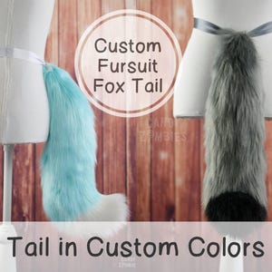 May include: Two furry fox tails, one light blue and one gray, attached to mannequins with white sashes. The text "Custom Fursuit Fox Tail" is in a circle above the tails. The text "Tail in Custom Colors" is at the bottom of the image.