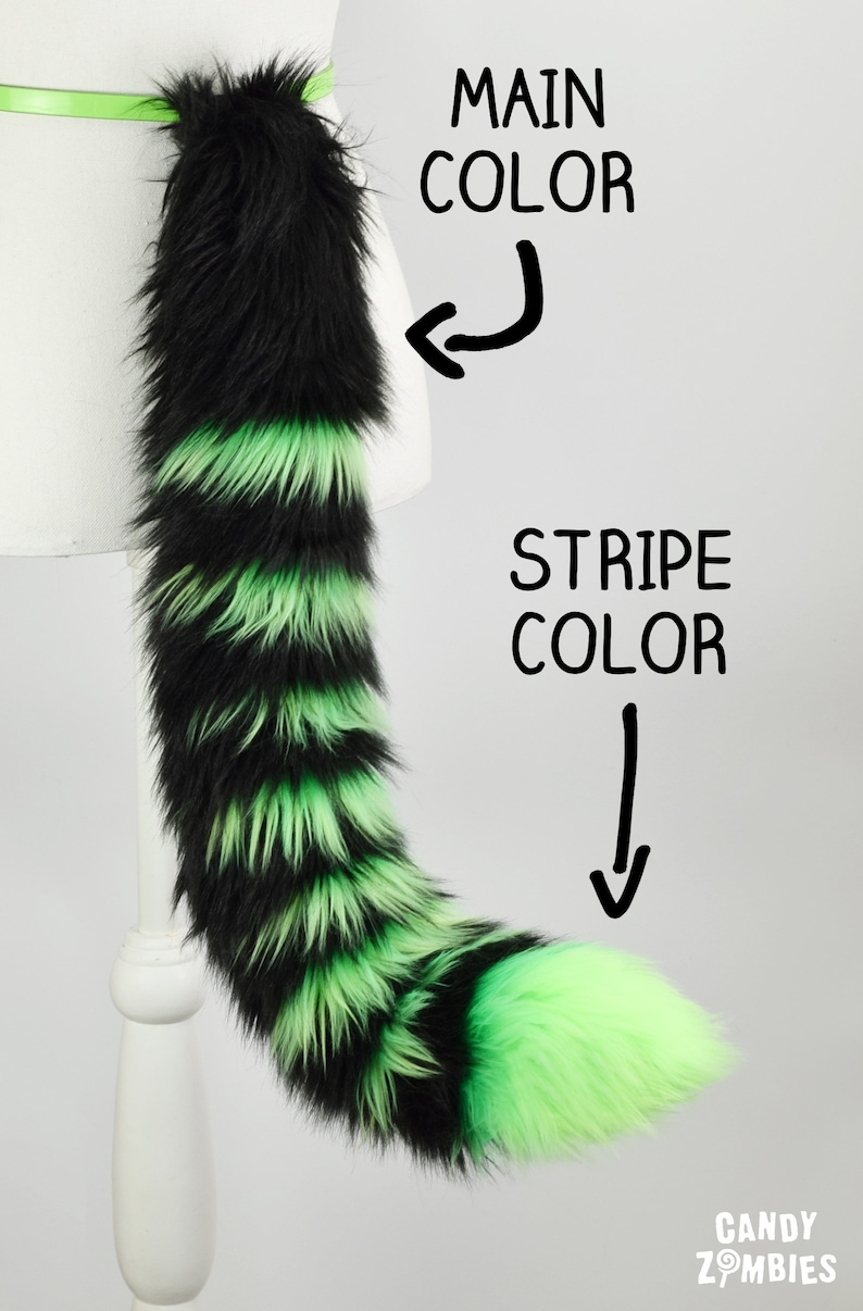May include: Black and green striped faux fur tail with a black base and a green tip. The tail is attached to a belt.