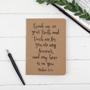 May include: A brown notebook with the text "Guide me in your truth and Teach me, for you are my Saviour, and my hope is in you Psalm 25:5" written in black cursive.
