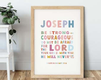 May include: A framed print with the name "JOSEPH" in colorful letters at the top. Below, the text reads "BE STRONG AND COURAGEOUS, DO NOT BE AFRAID FOR THE LORD, YOUR GOD IS WITH YOU; HE WILL NEVER LEAVE YOU" and "DEUTERONOMY 31:6".