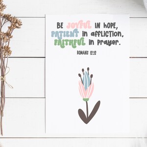 May include: A white card with a floral design and the text "BE JOYFUL IN HOPE, PATIENT in affliction, FAITHFUL in Prayer. ROMANS 12:12".