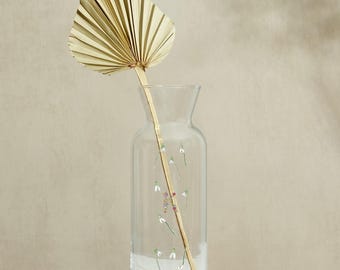 Jarrón de cristal con tallo de flor de nacimiento