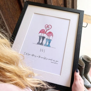May include: A framed print with a watercolor illustration of two pink flamingos standing in blue and black rain boots. The flamingos are forming a heart shape with their necks. The print includes the text "D&S" and a quote from William Shakespeare: "I do love nothing in the world so much as you."