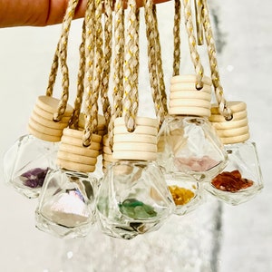 May include: A set of 10 car air fresheners with various colored crystals inside. Each air freshener is made of clear glass and has a wooden top with a string attached.
