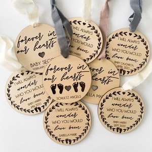 May include: Set of six wooden ornaments with a white ribbon. Each ornament features a different baby's name and birthdate, with the text "I will always wonder who you would have been".