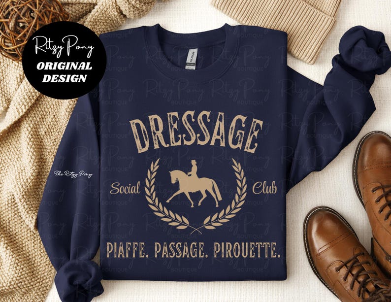 Pu&ograve; includere: Felpa blu navy con scritta beige "DRESSAGE Social Club" e grafica di cavallo e cavaliere. Il testo "PIAFFE. PASSAGE. PIROUETTE." &egrave; sotto. Design originale di Ritzy Pony.