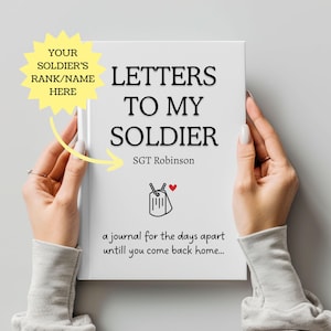Może przedstawiać: Biały dziennik zatytułowany "Letters to My Soldier" z tekstem "SGT Robinson" poniżej. Okładka zawiera grafikę z nieśmiertelnikiem i czerwone serce. Dziennik jest trzymany przez dwie ręce, a na dole znajduje się tekst "a journal for the days apart until you come back home..."