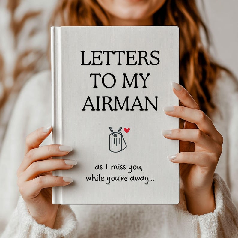 Op de afbeelding: Een wit dagboek met de tekst "Letters to my Airman" en een klein rood hartje. Het dagboek heeft een zwart-witte illustratie van een hondenpenning met een hartje erop. De tekst onder de titel luidt "as I miss you, while you're away..."