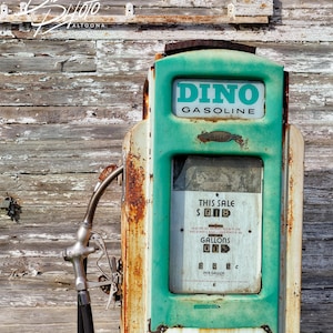 May include: A vintage green and white gas pump with a Sinclair logo featuring a red dinosaur. The pump has a price display that reads "This Sale $ 0.18 Gallons Up".