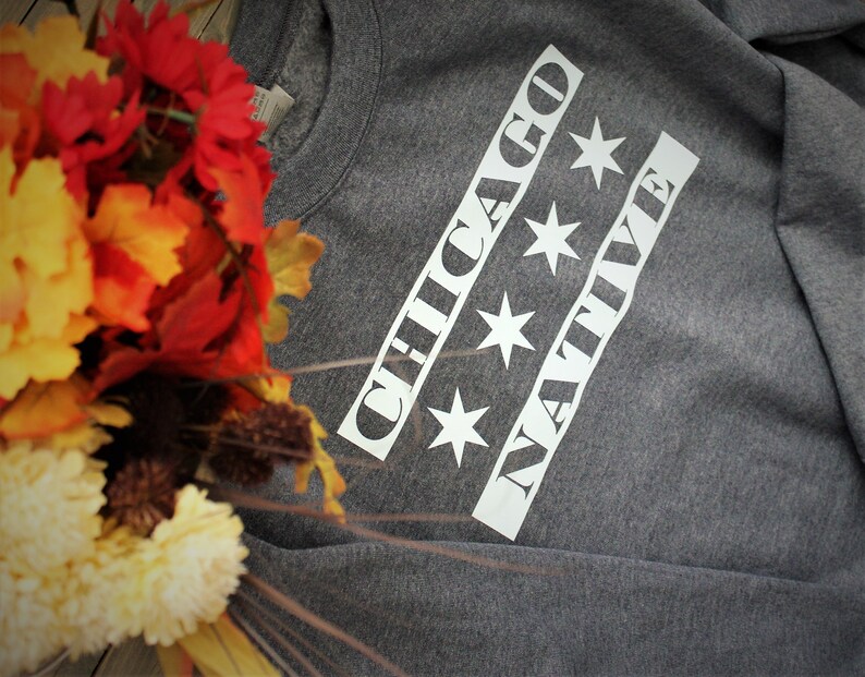 May include: Gray sweatshirt with white text that reads "CHICAGO NATIVE" with four white stars.