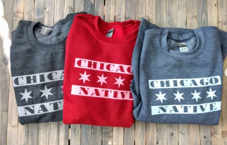 May include: Three sweatshirts with the text "Chicago Native" and six white stars on a red, gray, and dark gray background.