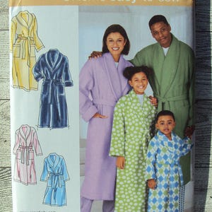 May include: A sewing pattern for making robes for adults and children. The pattern includes instructions for making a robe in a variety of colors and styles. The pattern is from Simplicity and is labeled "@Home easy-to-sew".